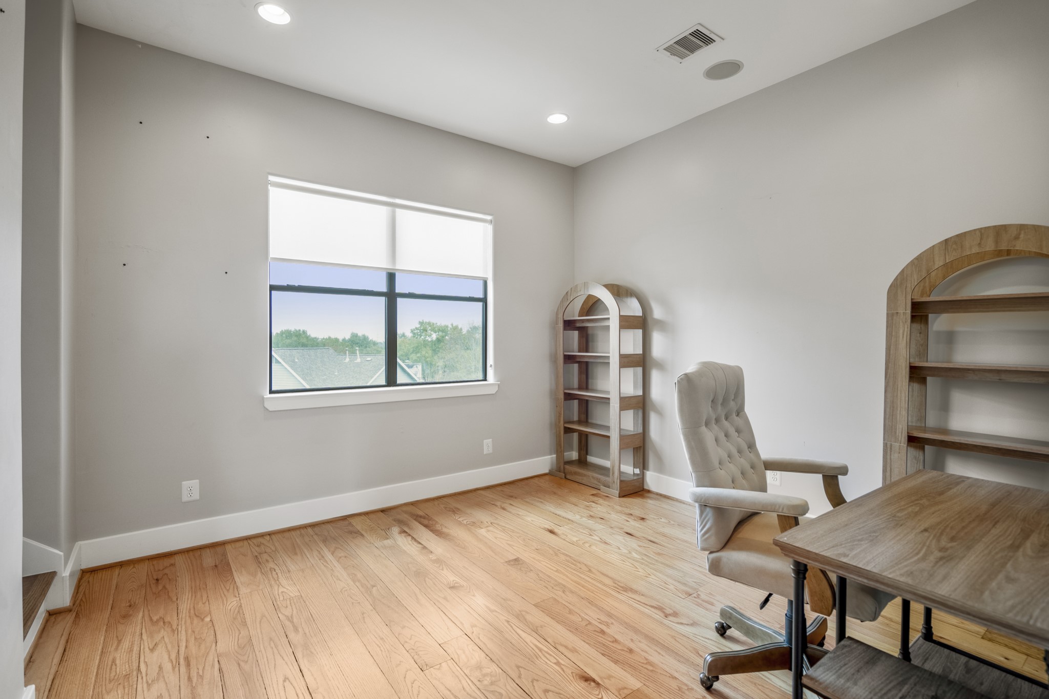 1310 West Dallas Street Houston, TX 77019 - Photo 37 of 50 Located on the third floor just beyond the upstairs landing, this dedicated study offers a quiet, light-filled space for work or creative use. Warm wood floors, recessed lighting, and a large window create an inviting setting that feels flexible yet purposeful—ideal for a home office, studio, or reading room