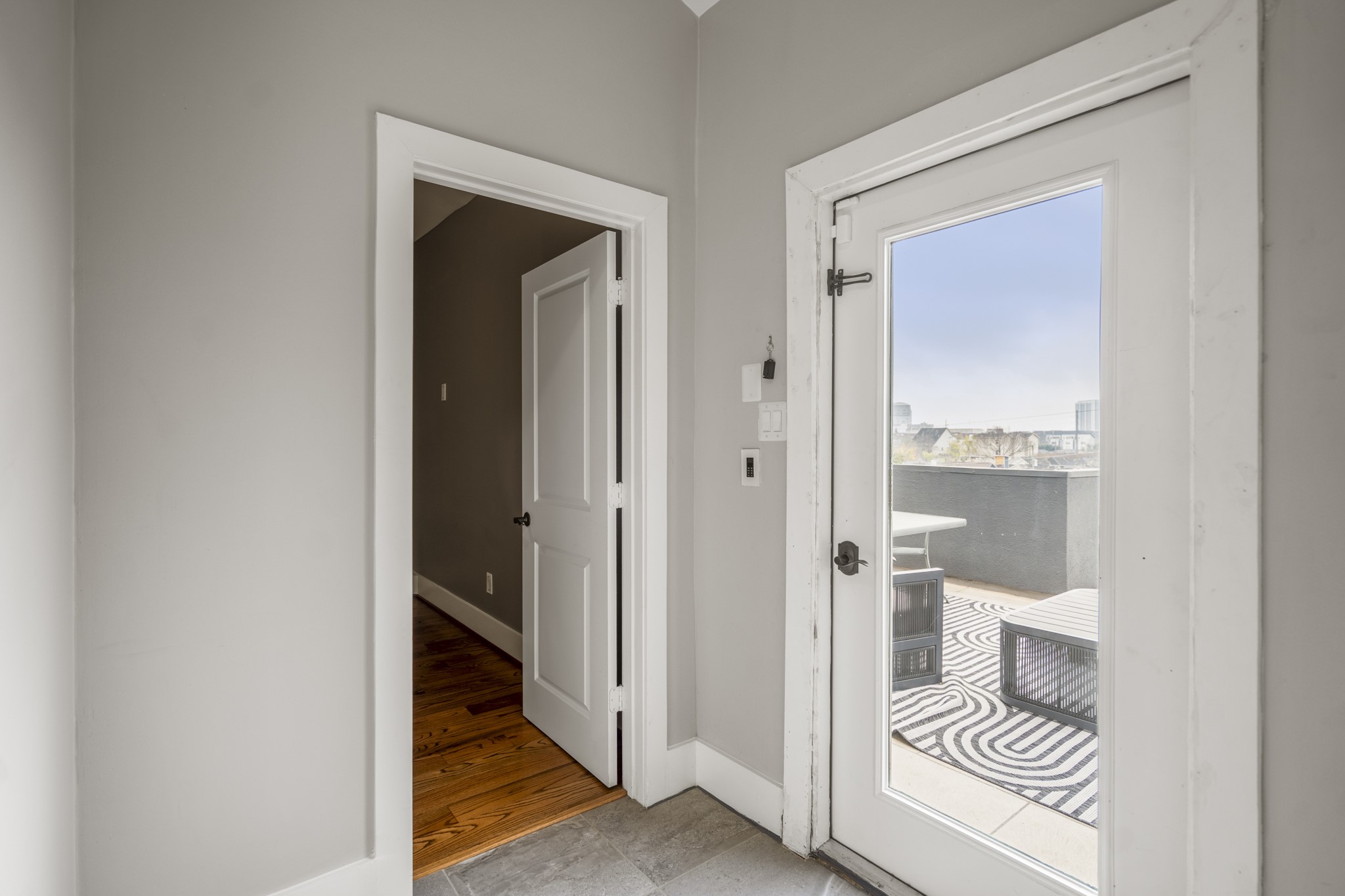 1310 West Dallas Street Houston, TX 77019 - Photo 39 of 50 At the fourth-floor landing, the home opens in two directions—one door leads back into the bedroom, while the glass door ahead steps out to the rooftop terrace. A simple transition point that makes indoor and outdoor living feel seamless at the top level