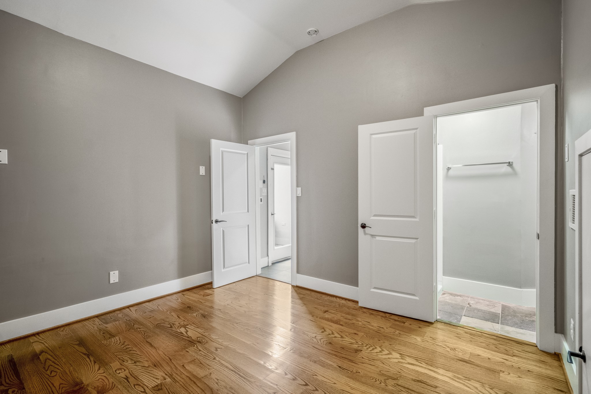 1310 West Dallas Street Houston, TX 77019 - Photo 40 of 50 Tucked away on the fourth floor, this bedroom offers vaulted ceilings, warm wood floors, and its own en-suite bath—ideal for guests or a private work-from-home setup while still feeling connected to the rest of the home.