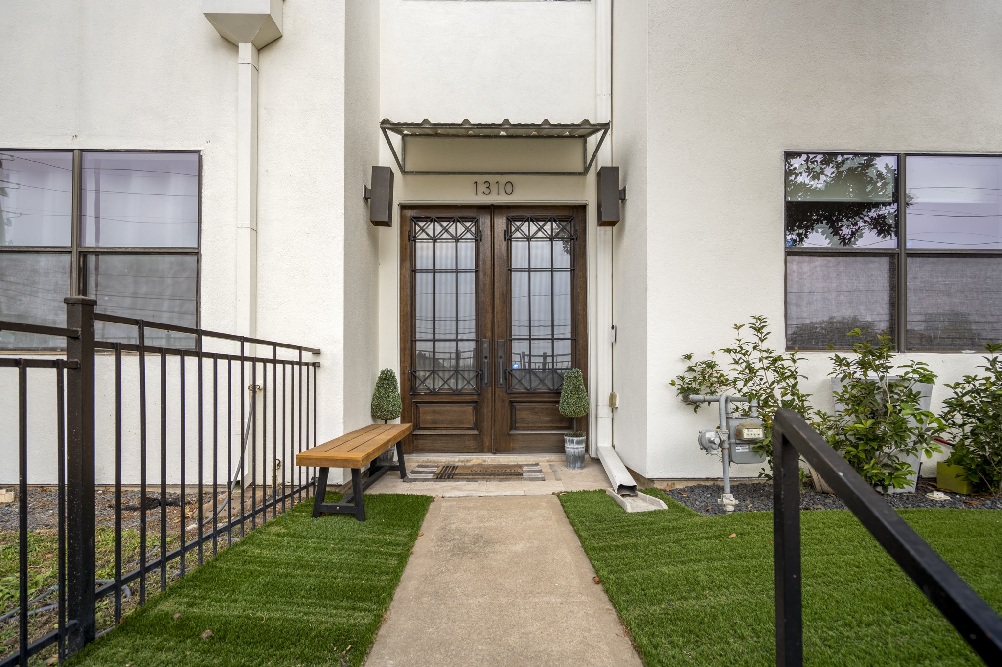 1310 West Dallas Street Houston, TX 77019 - Photo 6 of 50 The walk ends at the double front doors, a clear transition point before stepping inside to the foyer, with the first-floor bedroom just beyond the entry and the staircase leading up to the main living level.