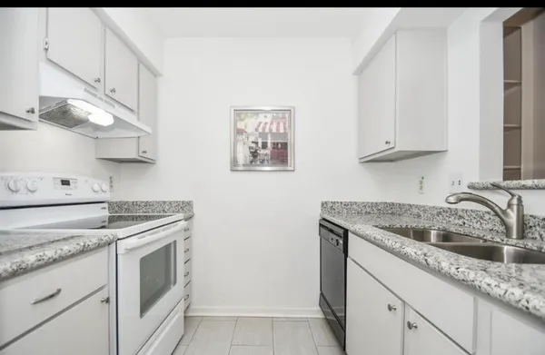 a kitchen with granite countertop a sink and a stove