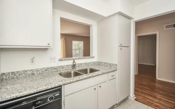 a kitchen with granite countertop a sink and cabinets