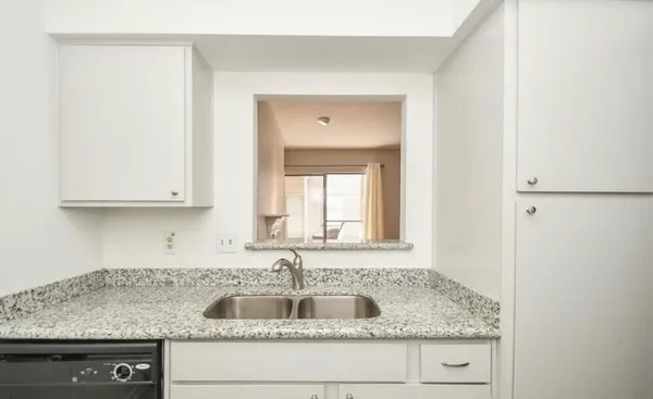 a kitchen with granite countertop a sink and a vanity