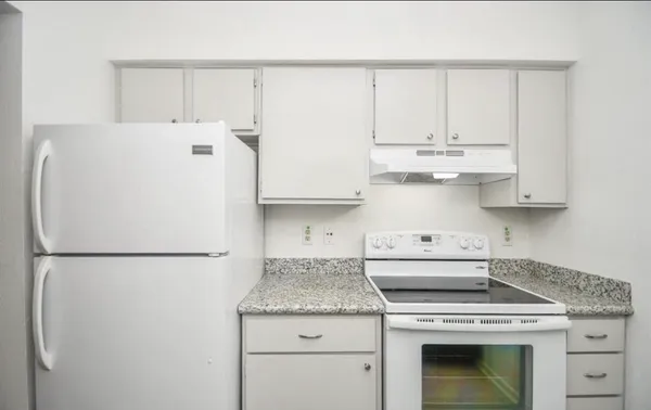 a kitchen with stainless steel appliances granite countertop white refrigerator sink and cabinets