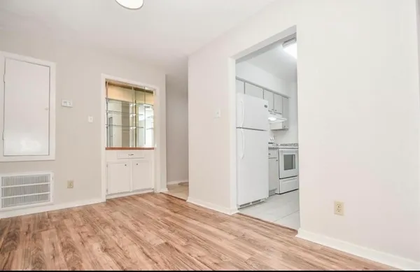 a view of empty room with wooden floor
