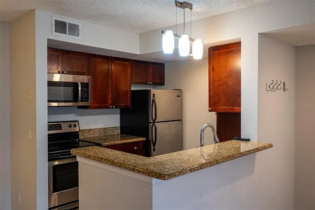 a kitchen with stainless steel appliances granite countertop a sink refrigerator and microwave