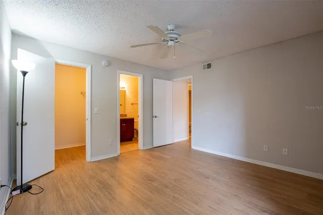 a view of an empty room with window and wooden floor