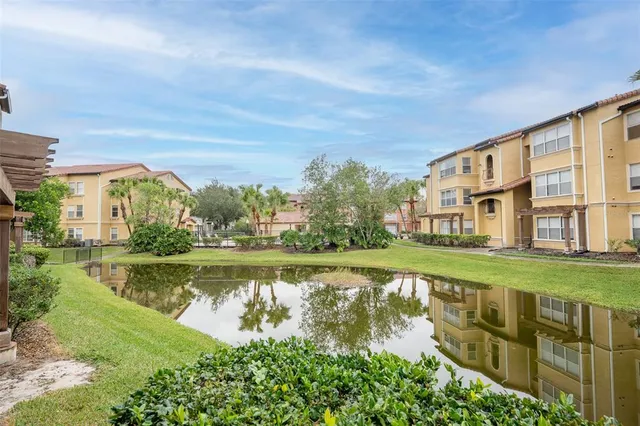a view of a lake with a big yard and large trees