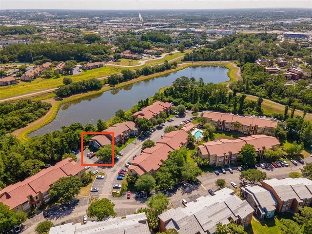 an aerial view of ocean and residential houses with outdoor space