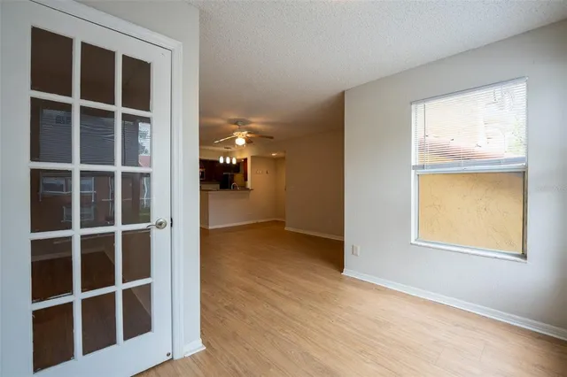 a view of a hallway with wooden floor and a window