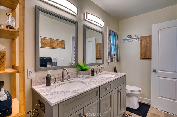 a bathroom with a granite countertop sink a toilet and shower