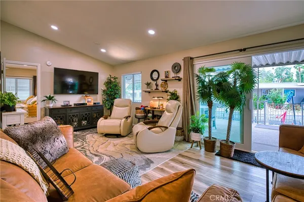 a living room with furniture kitchen view and a flat screen tv