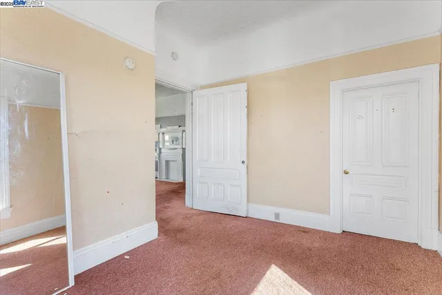 a view of a hallway with a door and a bathroom