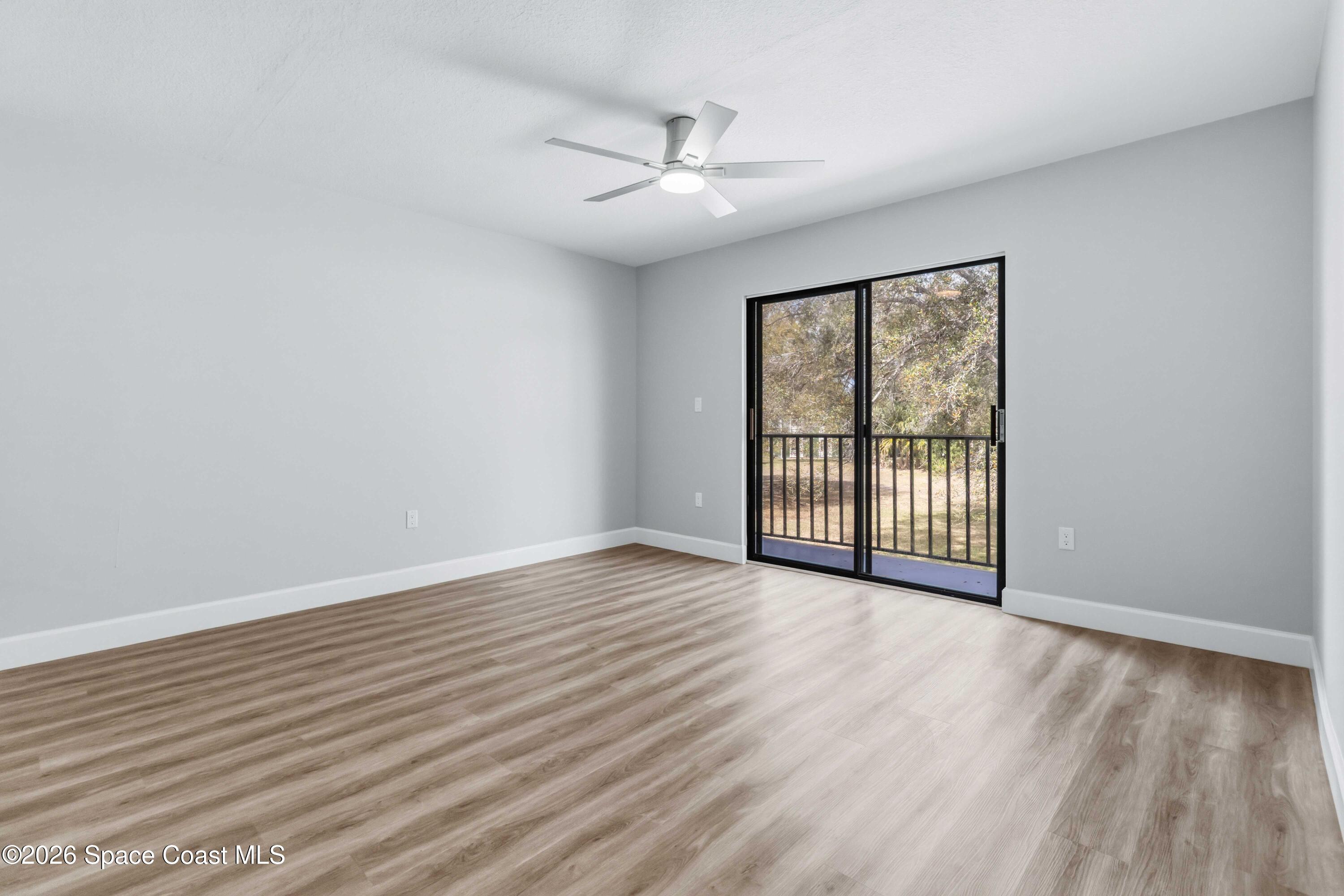 2258 Flower Tree Circle Melbourne, FL 32935 - Photo 12 of 30 a view of an empty room with wooden floor and a window
