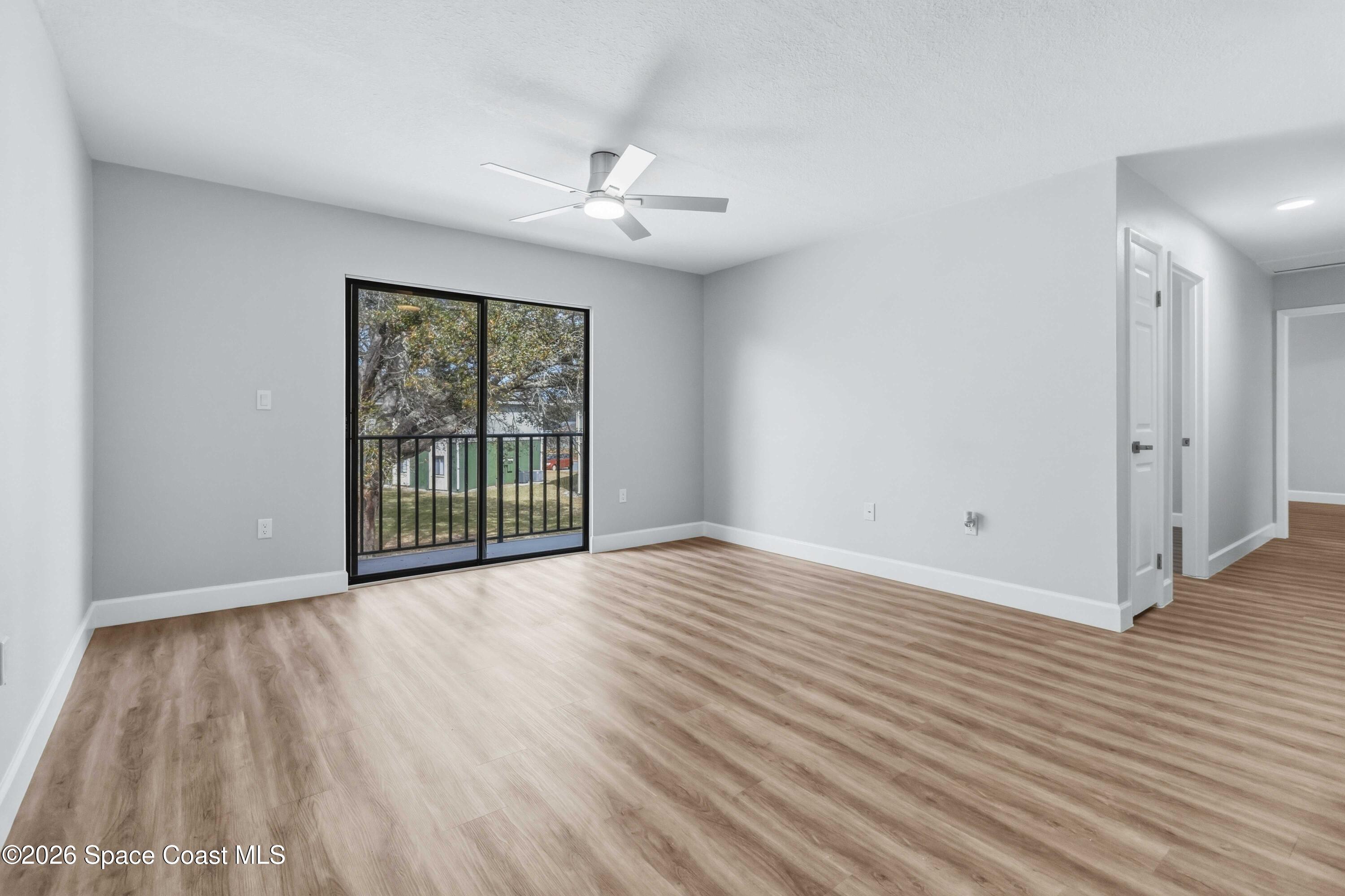 2258 Flower Tree Circle Melbourne, FL 32935 - Photo 14 of 30 a view of an empty room with wooden floor and a window