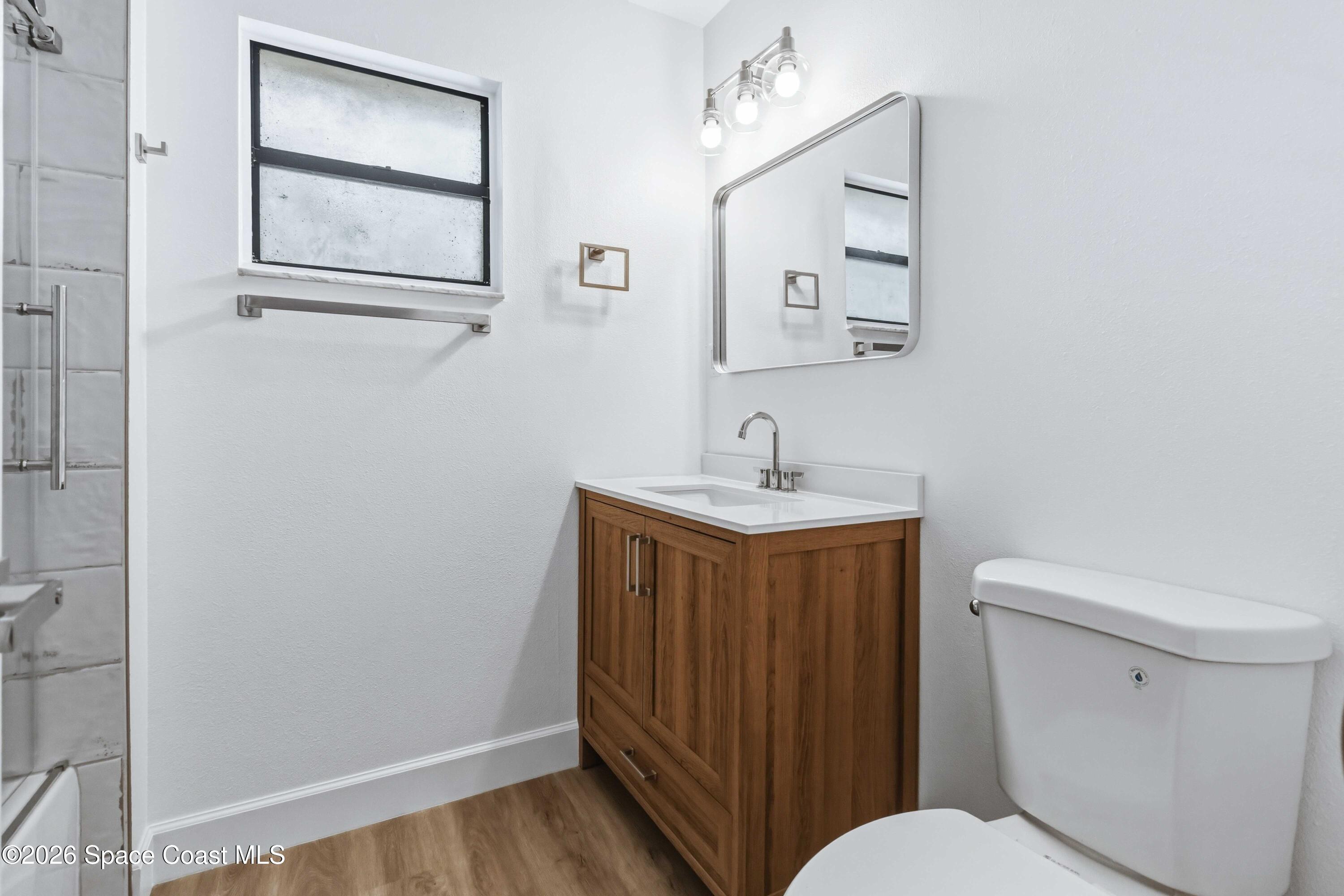 2258 Flower Tree Circle Melbourne, FL 32935 - Photo 18 of 30 a bathroom with a toilet a sink and mirror