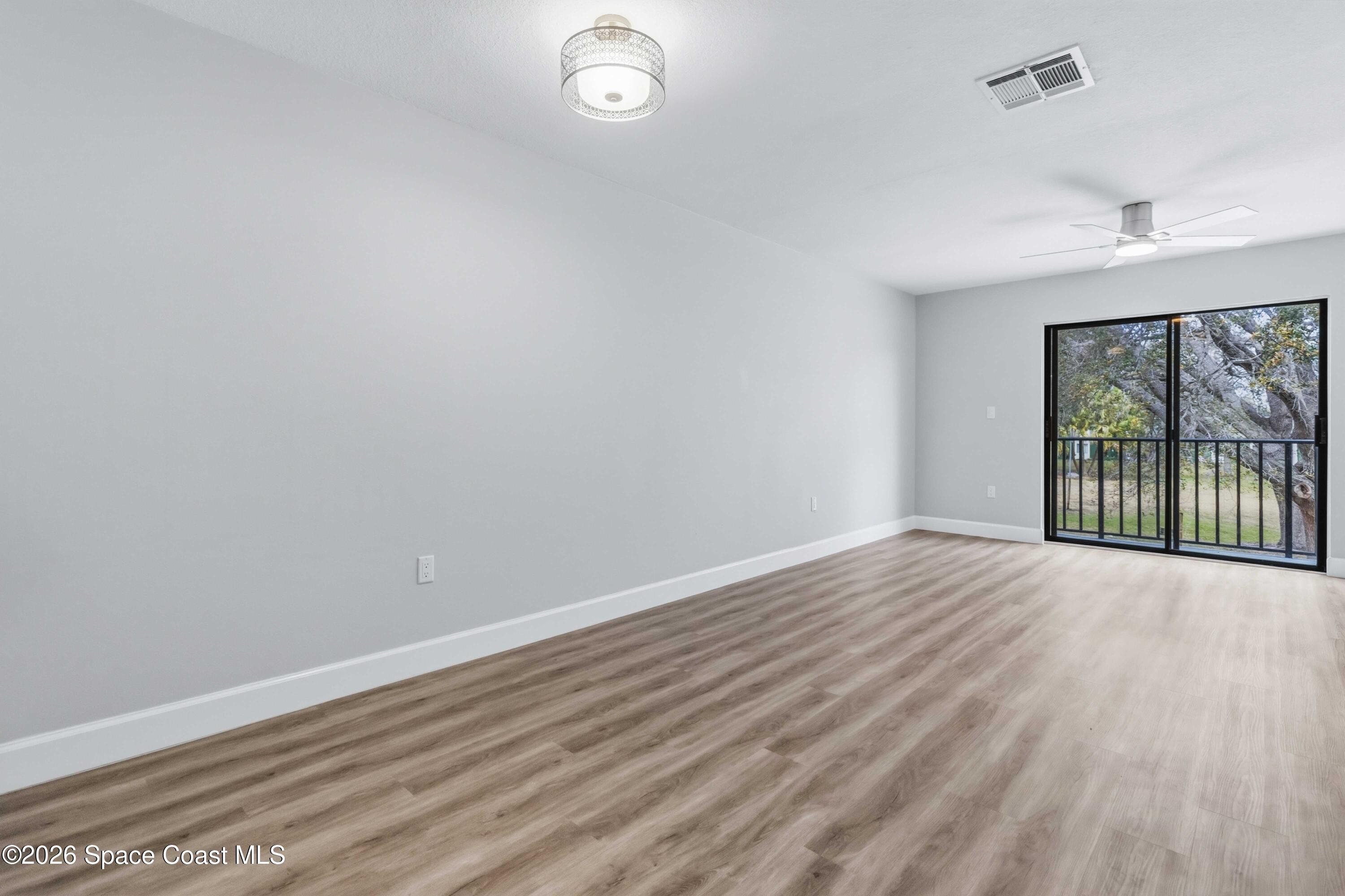 2258 Flower Tree Circle Melbourne, FL 32935 - Photo 4 of 30 wooden floor in an empty room with a window