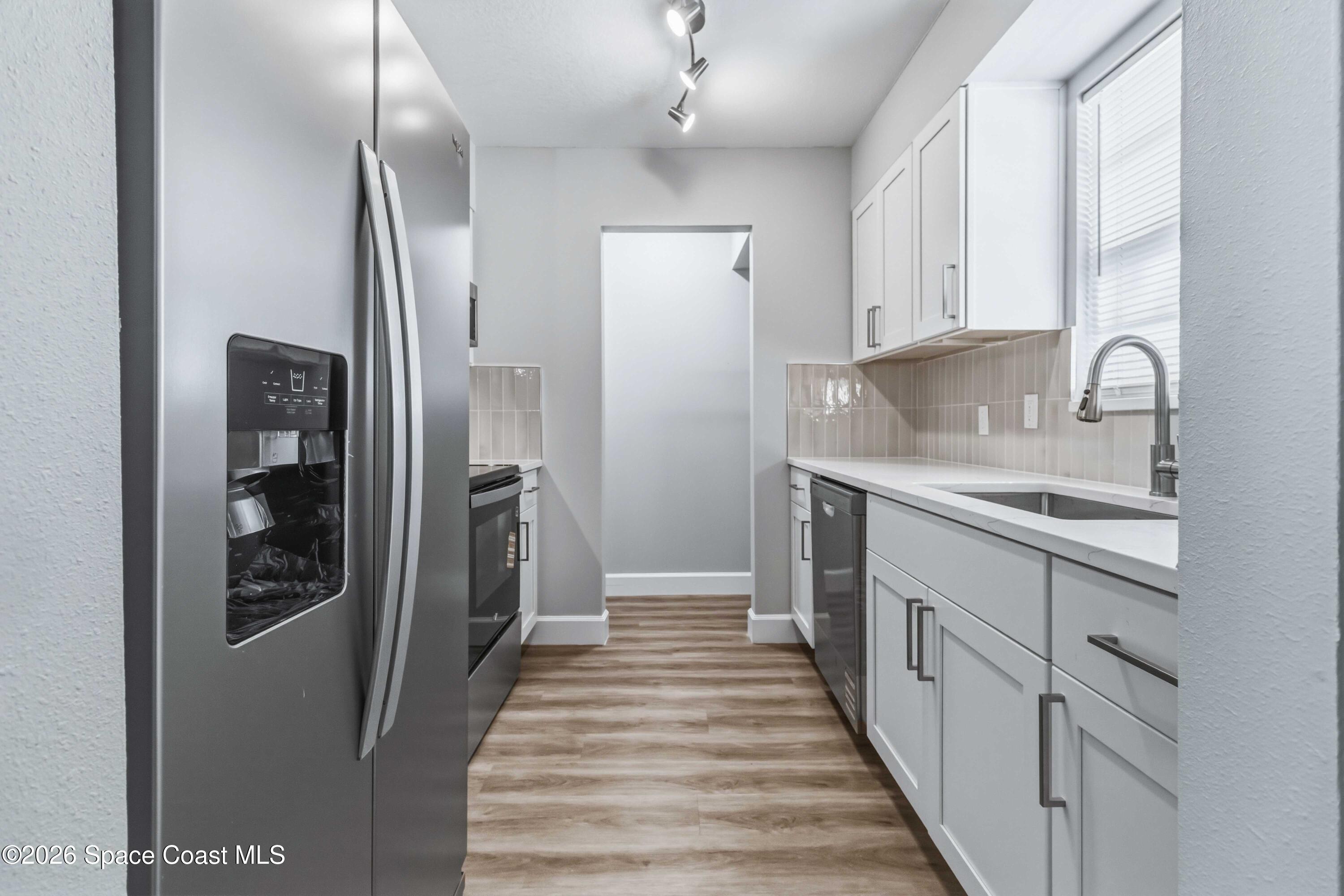2258 Flower Tree Circle Melbourne, FL 32935 - Photo 9 of 30 a kitchen with white cabinets and refrigerator