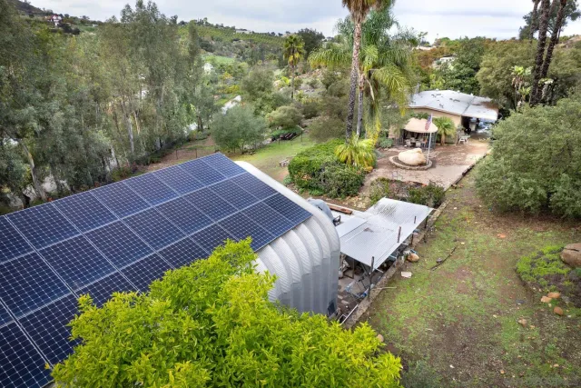 an aerial view of house with yard and mountain view in back