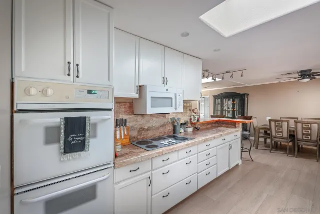 a kitchen with cabinets stainless steel appliances a sink and a refrigerator