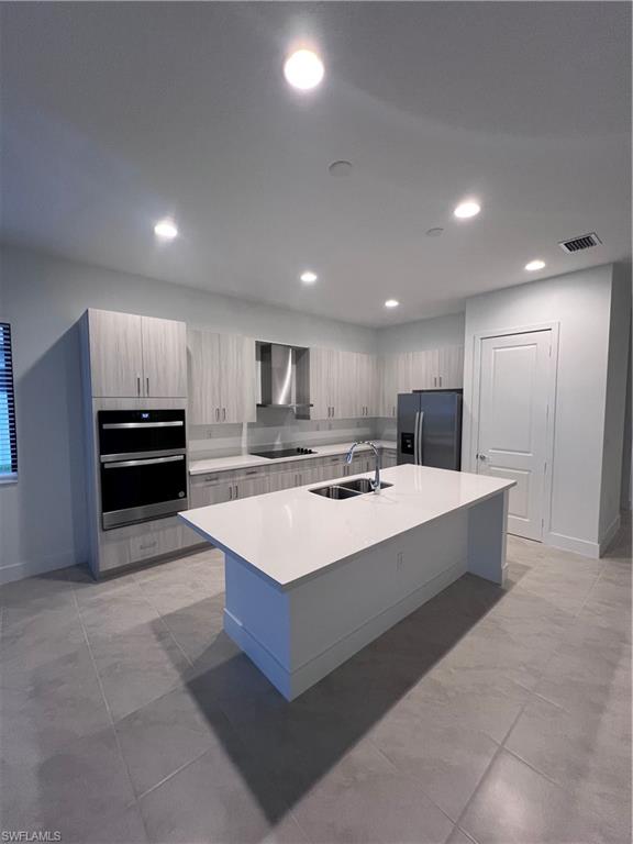 5261 Lamone Ln Avenue Immokalee, FL 34142 - Photo 2 of 14 Kitchen with sink, an island with sink, fridge, double oven, and extractor fan