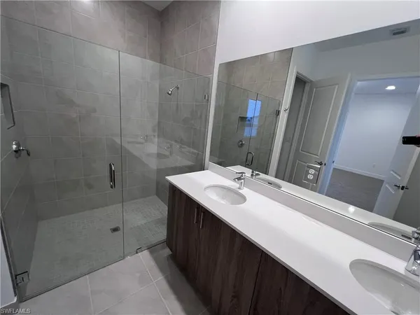 a bathroom with a sink a shower and a mirror