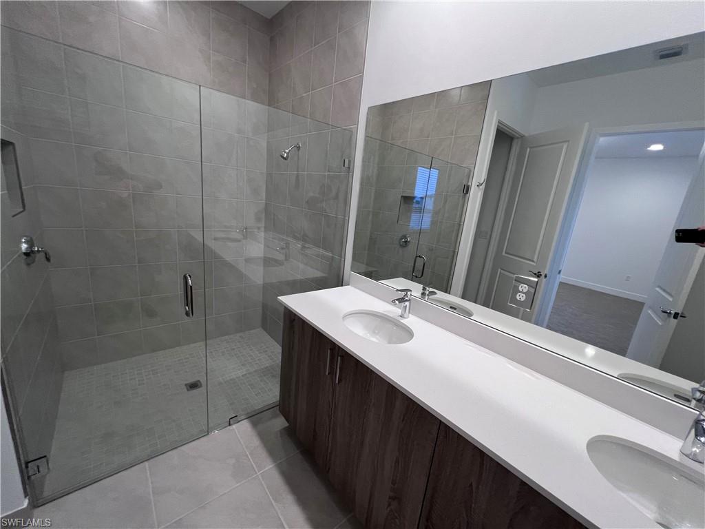 5261 Lamone Ln Avenue Immokalee, FL 34142 - Photo 6 of 14 Bathroom with vanity, tile patterned flooring, and an enclosed shower