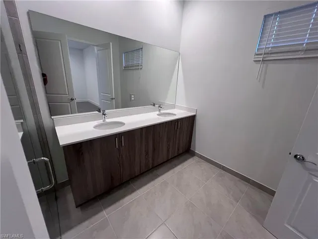 a bathroom with a double vanity sink and mirror