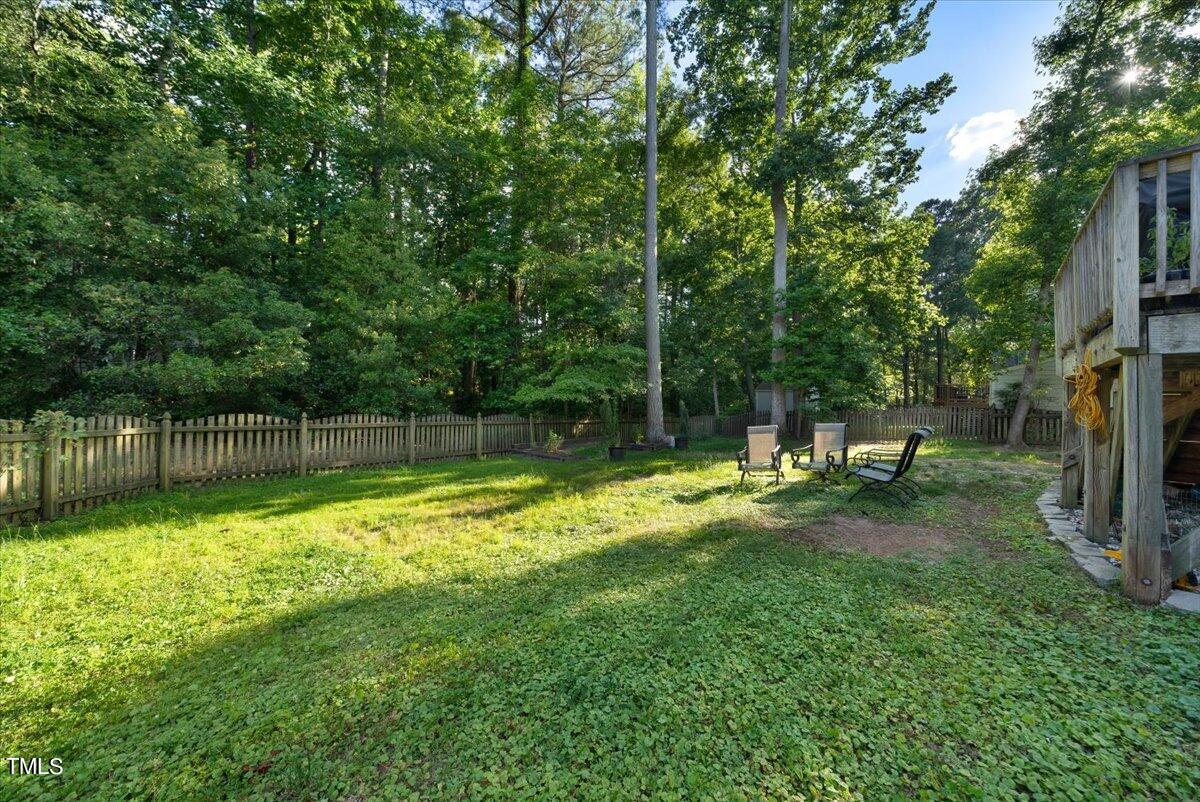 11905 Radner Way Raleigh, NC 27613 - Photo 23 of 35 a backyard of a house with plants and large tree