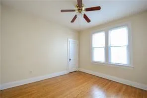 an empty room with a window and a fan
