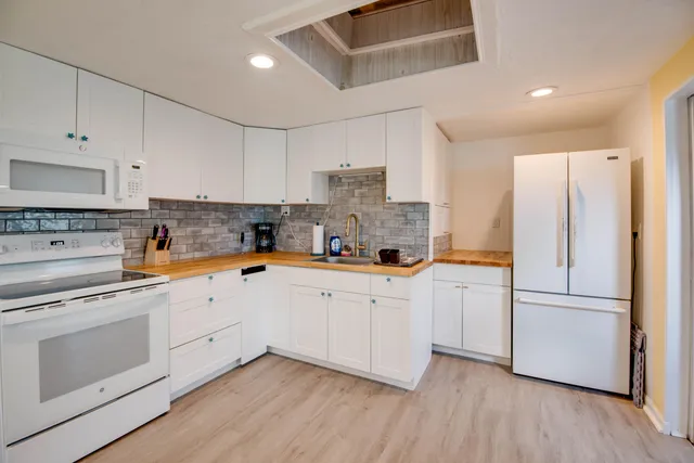 a kitchen with cabinets stainless steel appliances and wooden floor