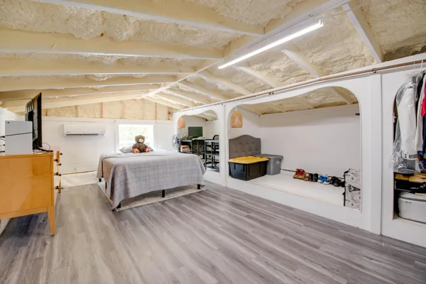 a bedroom with furniture and a wooden floor