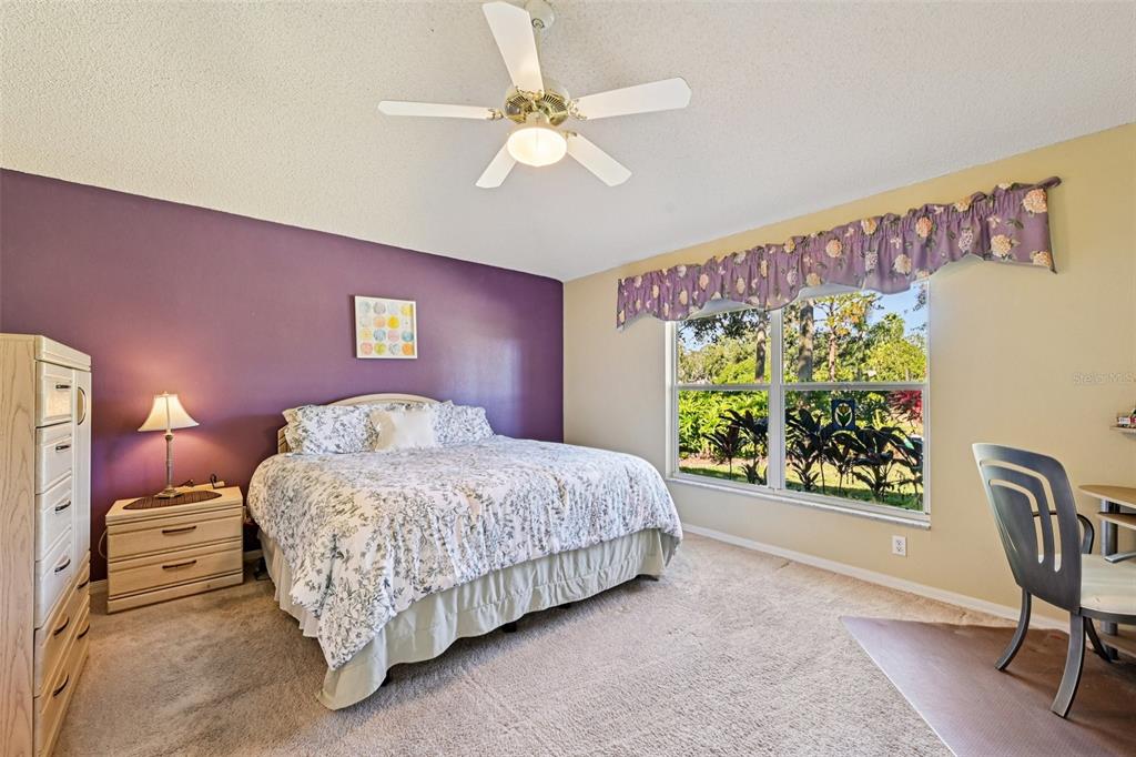 2215 Olive Branch Drive Sun City Center, FL 33573 - Photo 13 of 60 a bedroom with a bed painting on wall and a large window