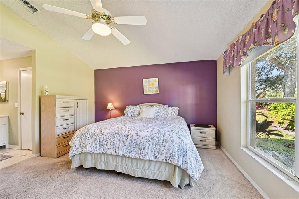 2215 Olive Branch Drive Sun City Center, FL 33573 - Photo 14 of 60 a bedroom with a bed and a chandelier