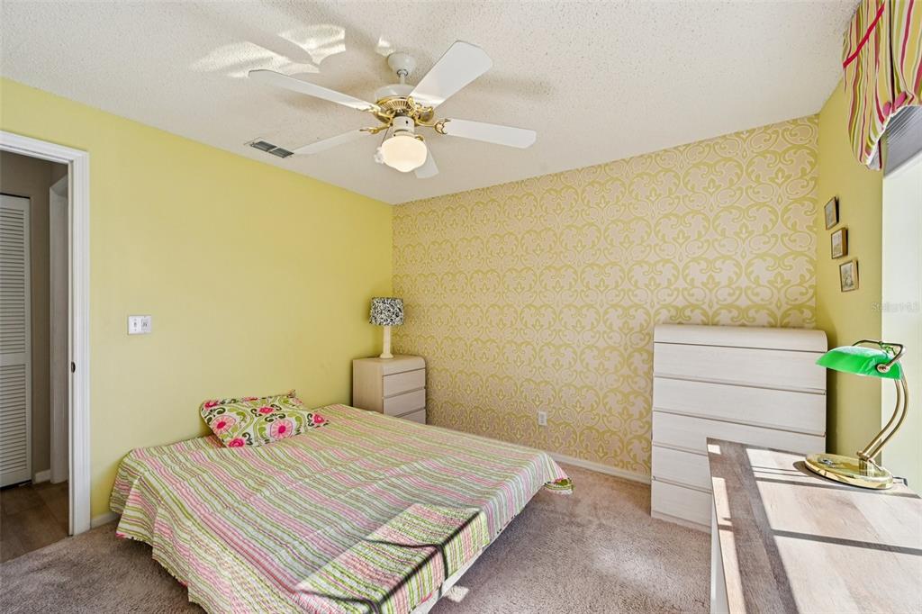 2215 Olive Branch Drive Sun City Center, FL 33573 - Photo 18 of 60 a bedroom with a bed and ceiling fan