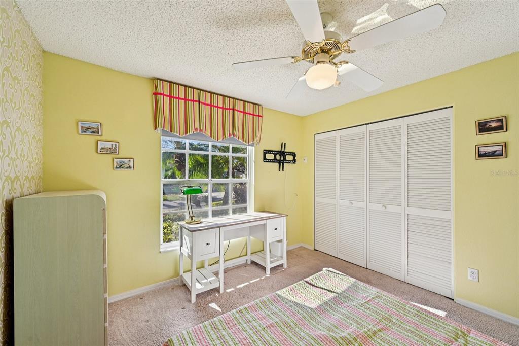 2215 Olive Branch Drive Sun City Center, FL 33573 - Photo 19 of 60 a workspace with wooden floor and a ceiling fan