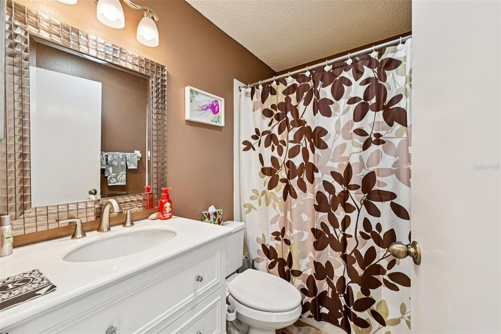 2215 Olive Branch Drive Sun City Center, FL 33573 - Photo 21 of 60 a bathroom with a sink a toilet and shower curtain