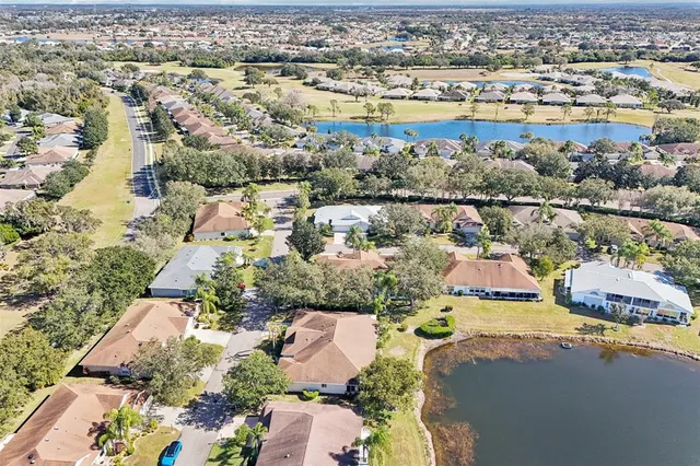 an aerial view of a house with a yard and covered with trees