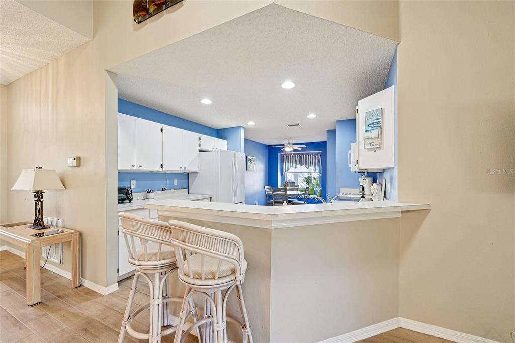 2215 Olive Branch Drive Sun City Center, FL 33573 - Photo 7 of 60 a kitchen with kitchen island a stove a table and chairs