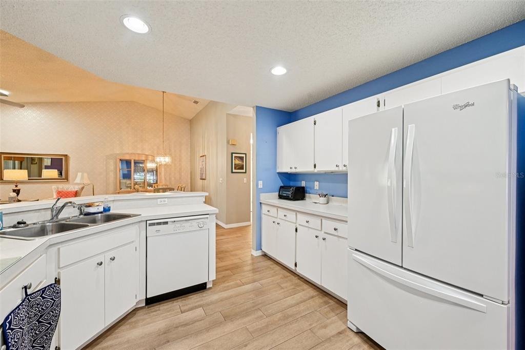 2215 Olive Branch Drive Sun City Center, FL 33573 - Photo 9 of 60 a kitchen with white cabinets and white appliances