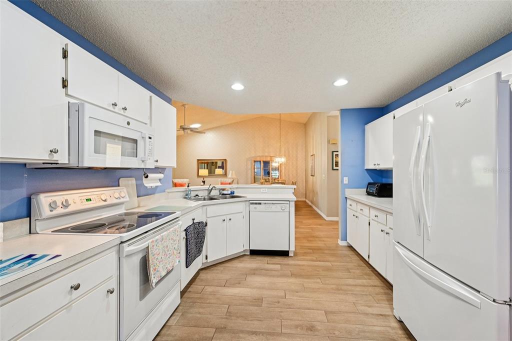 2215 Olive Branch Drive Sun City Center, FL 33573 - Photo 10 of 60 a kitchen with white cabinets and white appliances