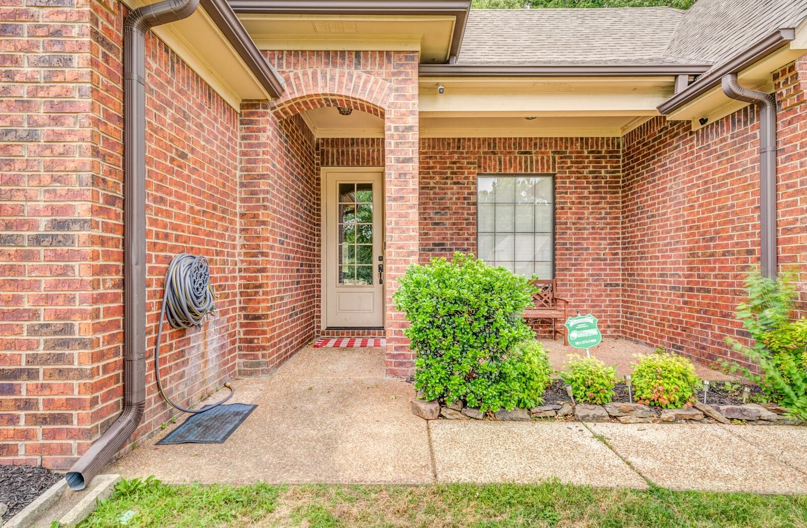 4671 Hampton Ridge Lane Bartlett, TN 38002 - Photo 5 of 40 Brick exterior featuring a covered entry porch, an arched doorway, and a multi-pane glass entry door