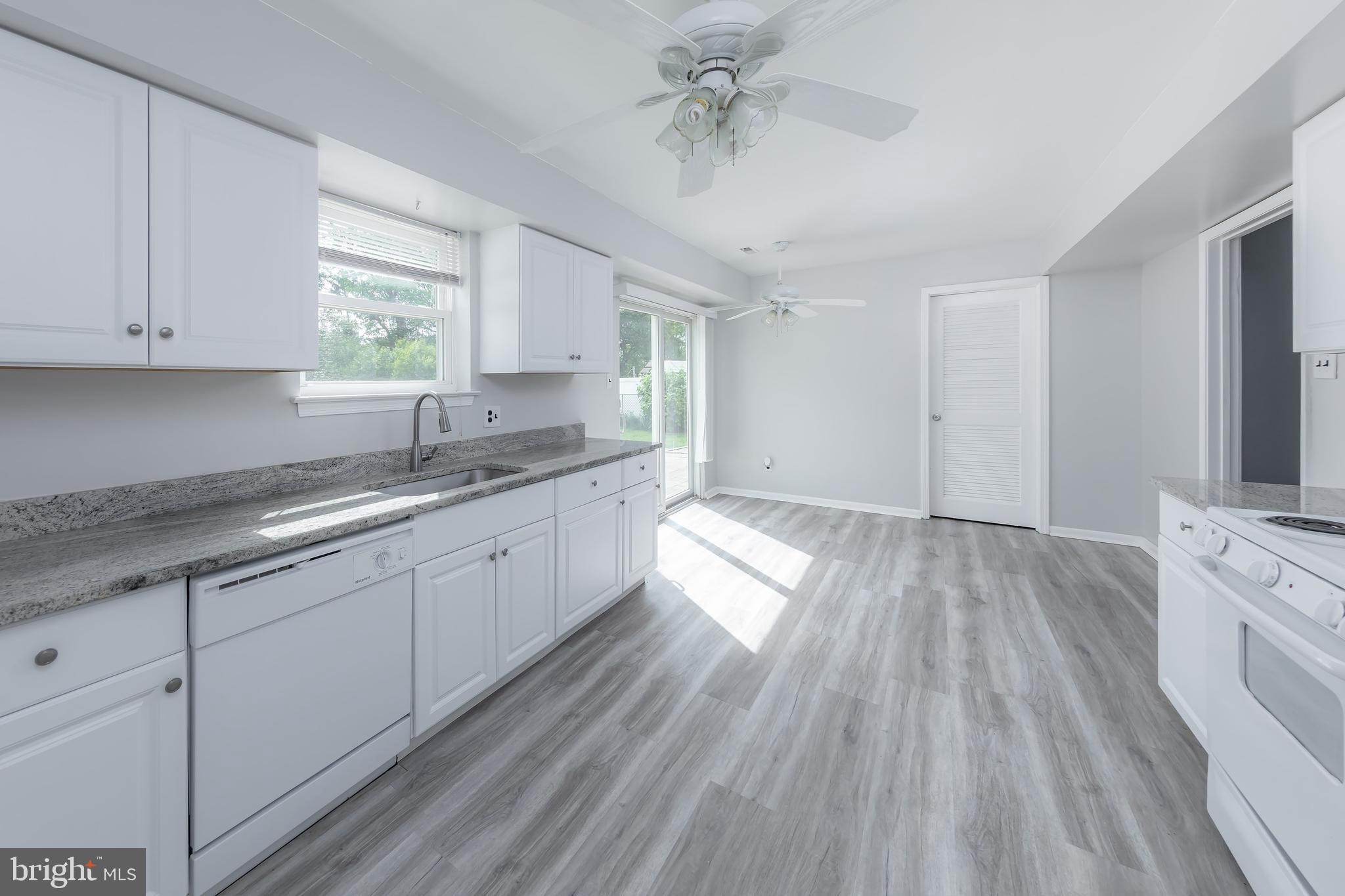 75 Hartford Road Sewell, NJ 08080 - Photo 14 of 23 a kitchen with granite countertop wooden floors white cabinets and window