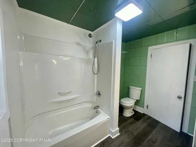 a bathroom with a shower a toilet and a shower