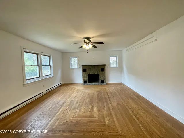 a view of an empty room with a fireplace and a window