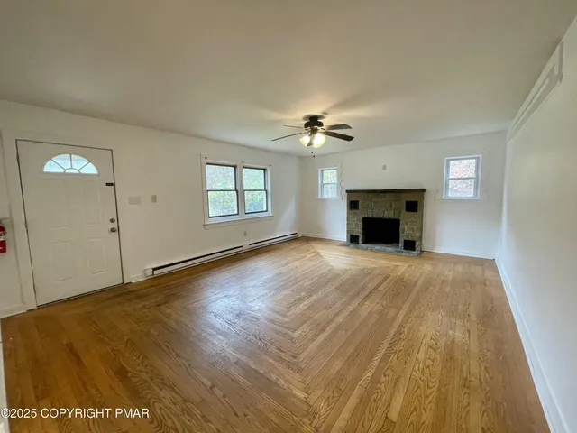 an empty room with windows and fireplace