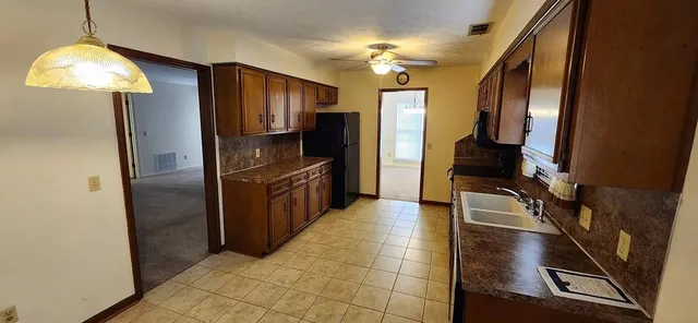 a kitchen with granite countertop stainless steel appliances a counter space and cabinets