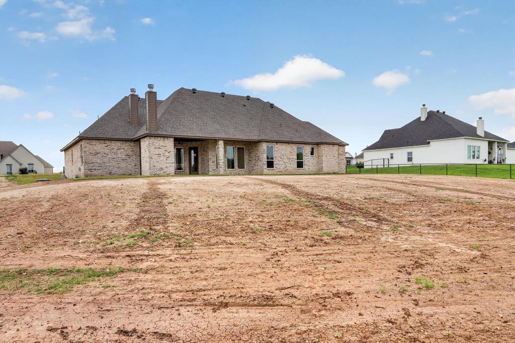 471 Red Bird Drive Springtown, TX 76082 - Photo 35 of 35 Expansive rear exterior featuring a brick facade and multiple window banks