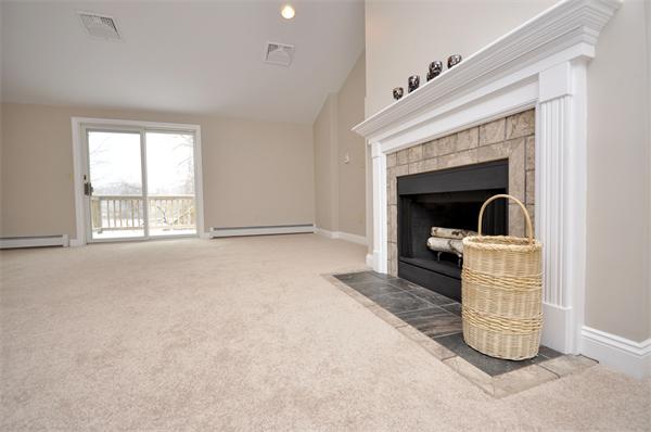 13 Meadow Road Beverly, MA 01915 - Photo 8 of 20 a living room with a fireplace furniture a ceiling fan and a window
