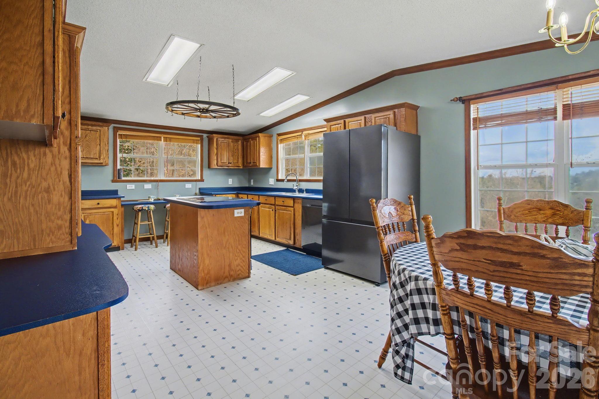 74 Chambers Road Weaverville, NC 28787 - Photo 15 of 43 a kitchen with stainless steel appliances granite countertop a stove a refrigerator a dining table and chairs with wooden floor